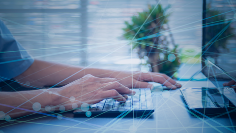 Effiziente SaaS-Lösung der HZD: die Sachbearbeitungskomponente FISBOX® SBK im Kurzvideo Close-up auf die Hände eines Mannes bei der Arbeit am Computer mit darüber gelegter halbtransparenter Grafik, die ein digitales Netzwerk symbolisiert